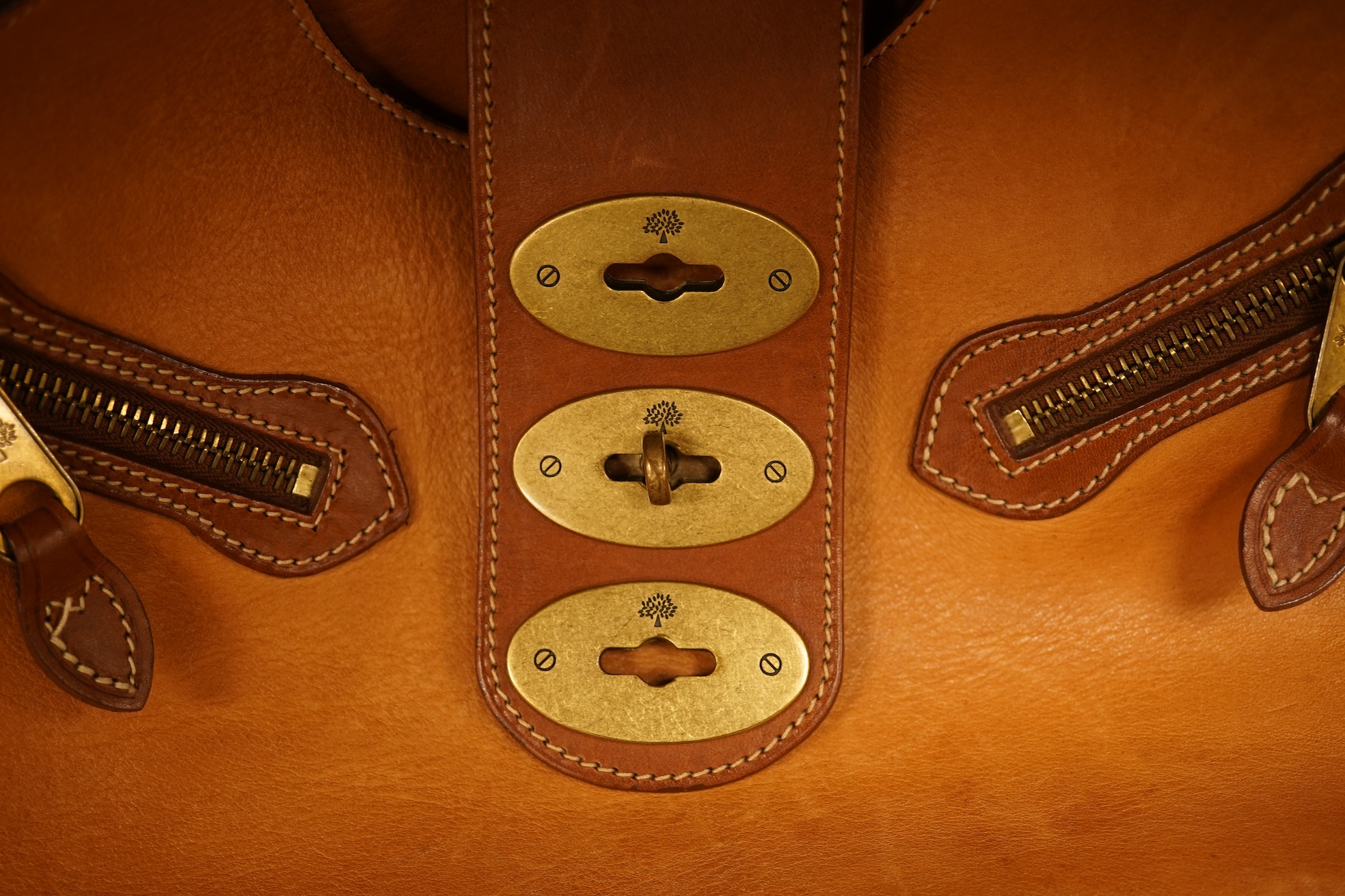 A Mulberry tote two zip, three postman clasps,tan leather with dark brown trim.handbag